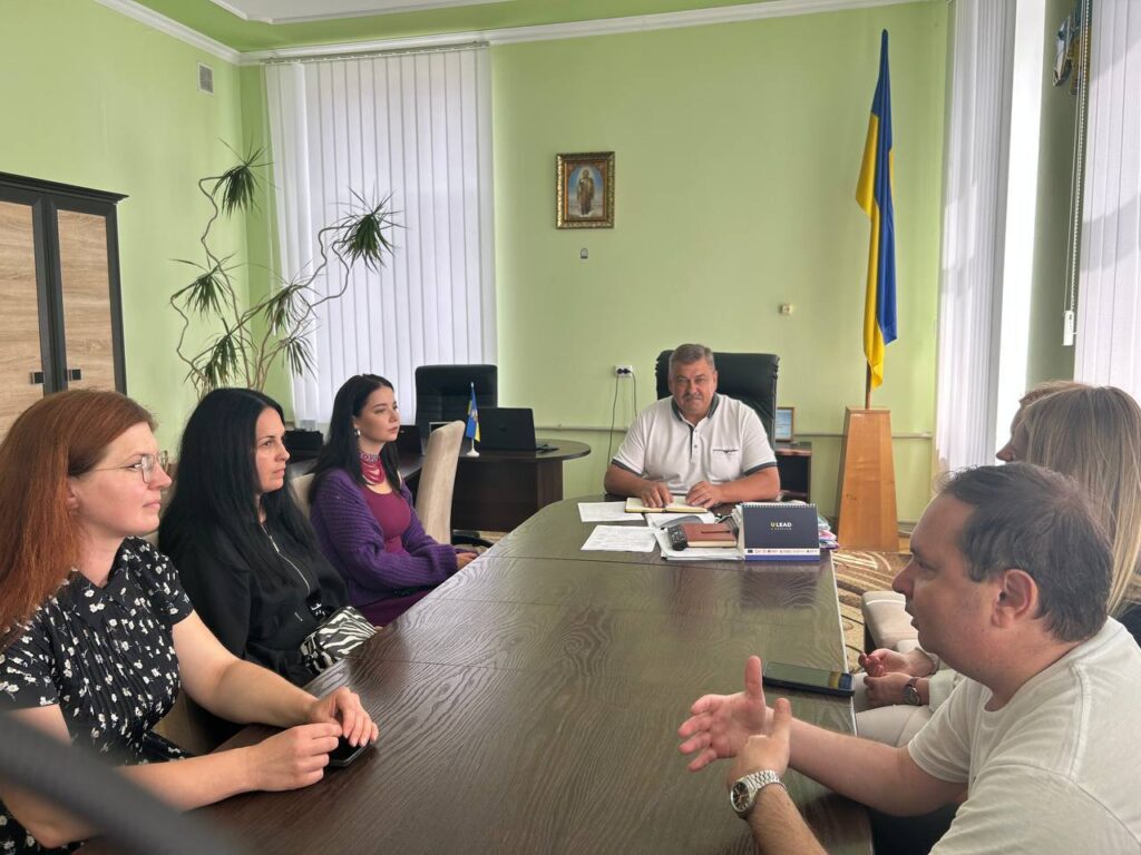 Зустріч у сучасному офісі з українським прапором.