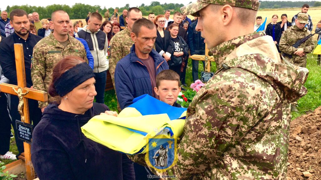 Церемонія на цвинтарі з українським прапором