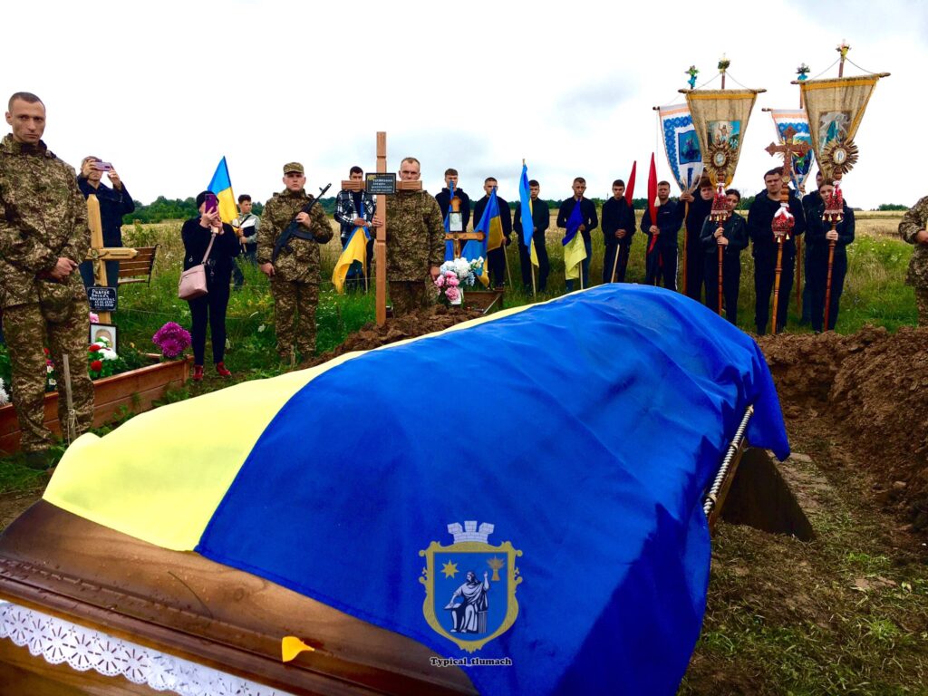 Церемонія похорону з військовими та прапорами України.