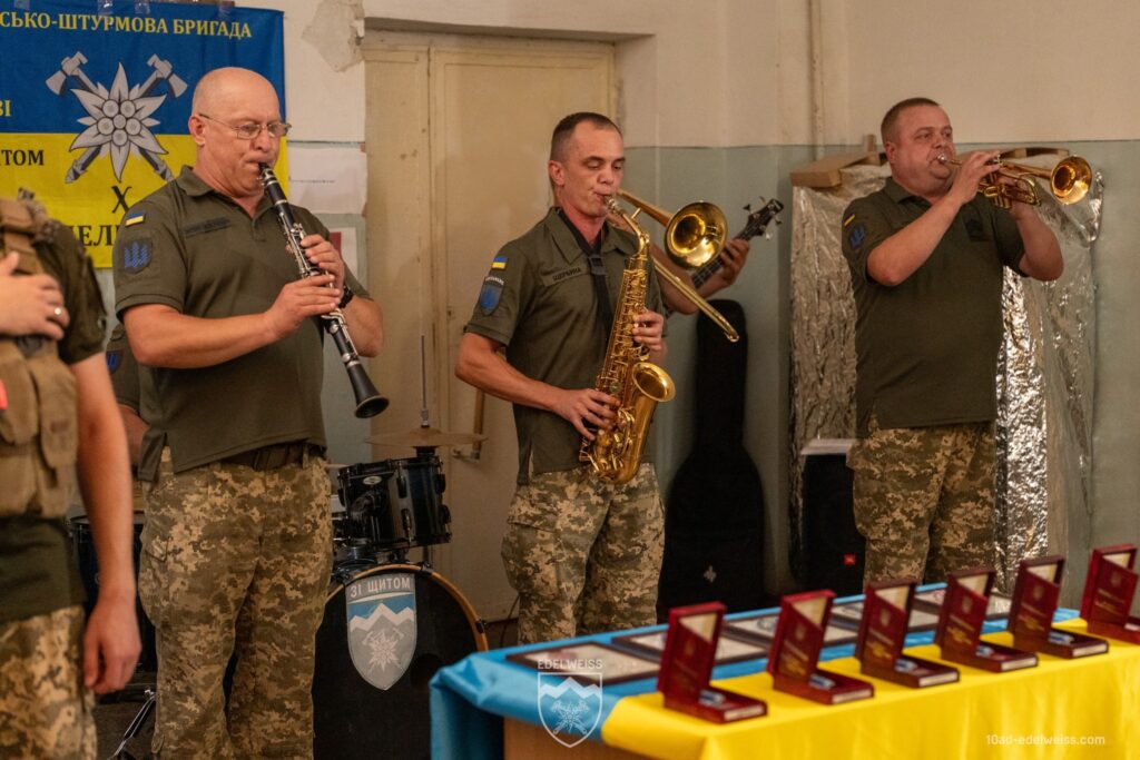 Військовий оркестр грає на музичних інструментах.