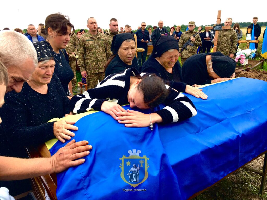 Сім'я оплакує загиблого військового на похороні.