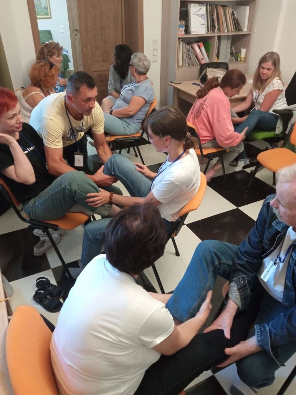 Люди сидять у колі на тренінгу.