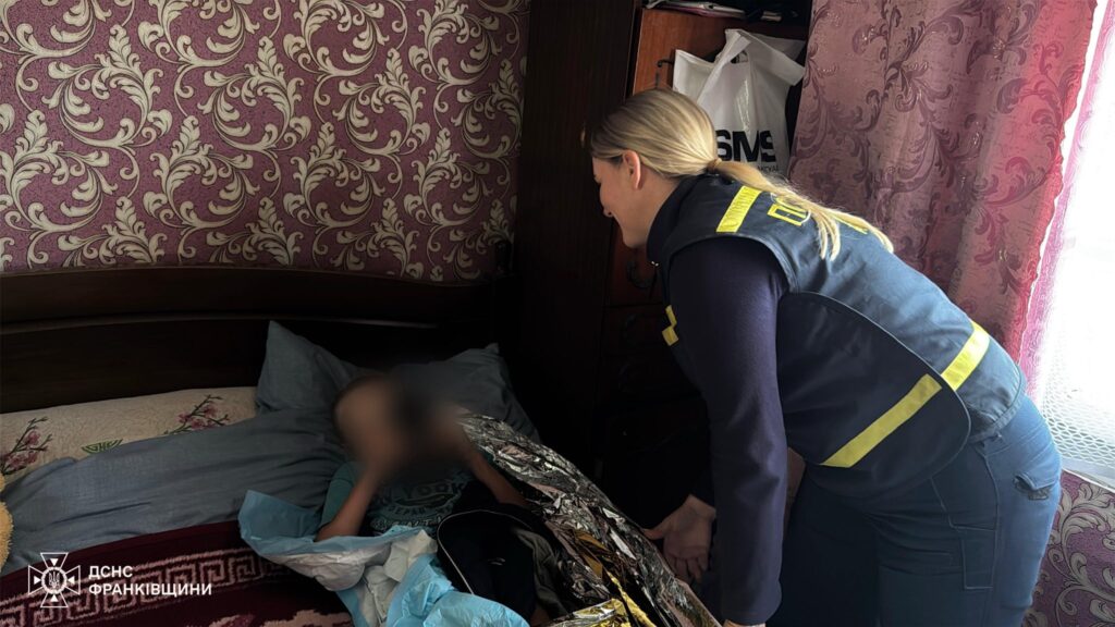 Рятувальник допомагає людині в ліжку вдома.