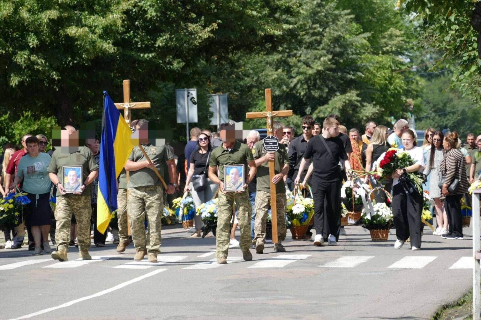 Похоронна процесія з прапором України, військові несуть хрести.