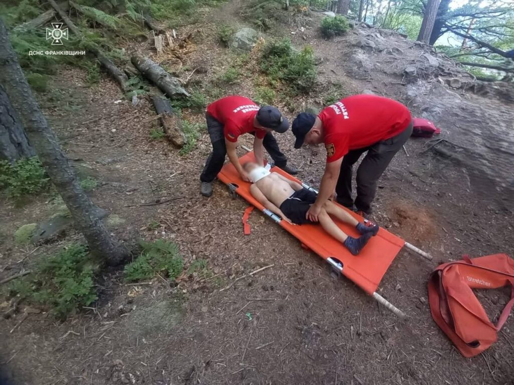 Рятувальники допомагають постраждалому на носилках у лісі.