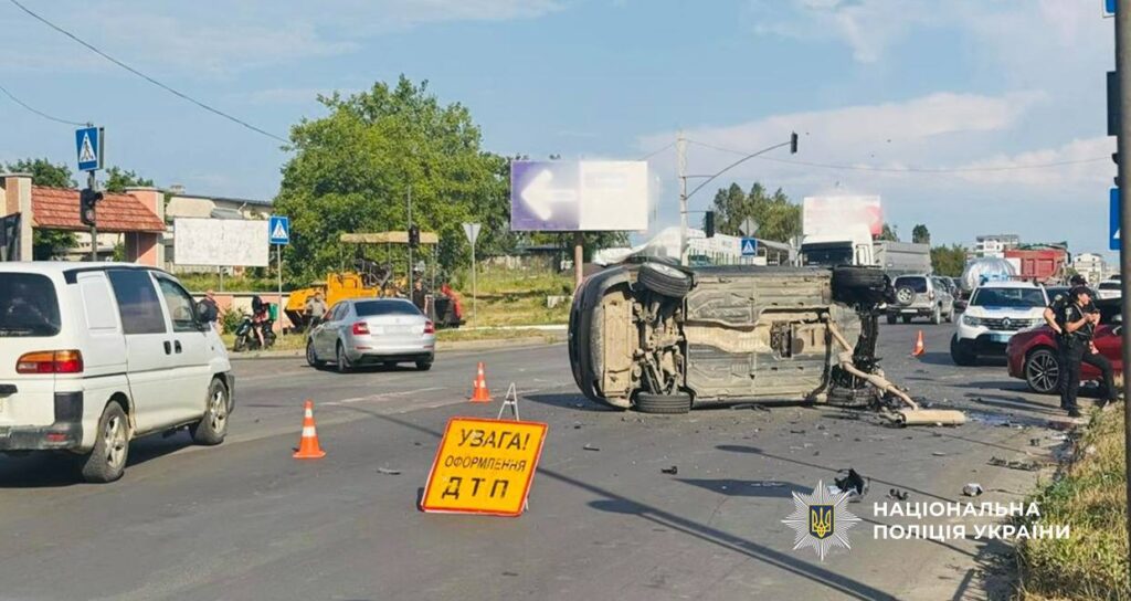 ДТП на дорозі, перекинутий автомобіль, попереджувальний знак.