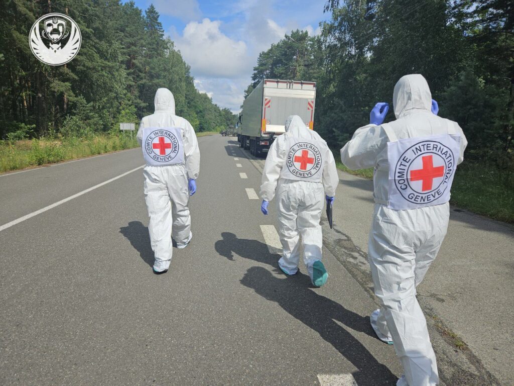 Працівники Червоного Хреста на дорозі в лісі.