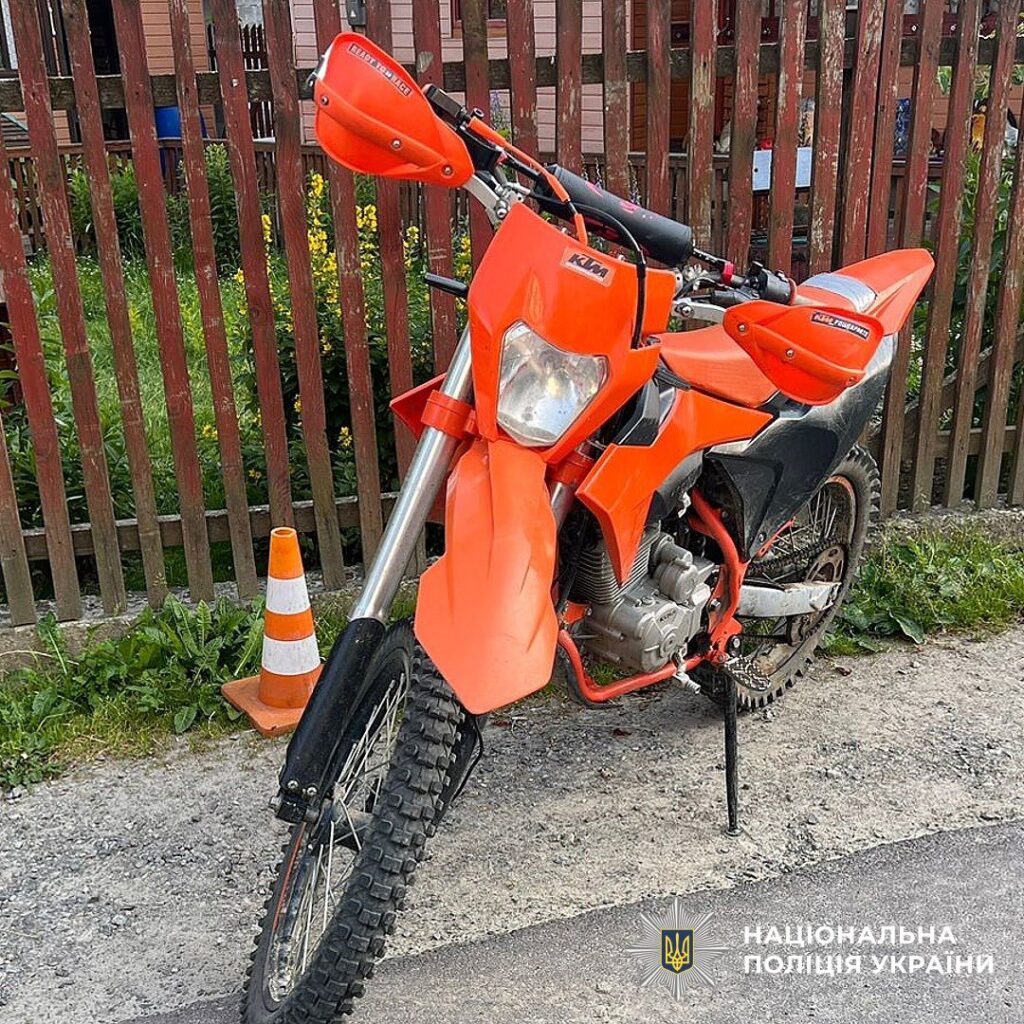 Помаранчевий мотоцикл KTM біля паркану