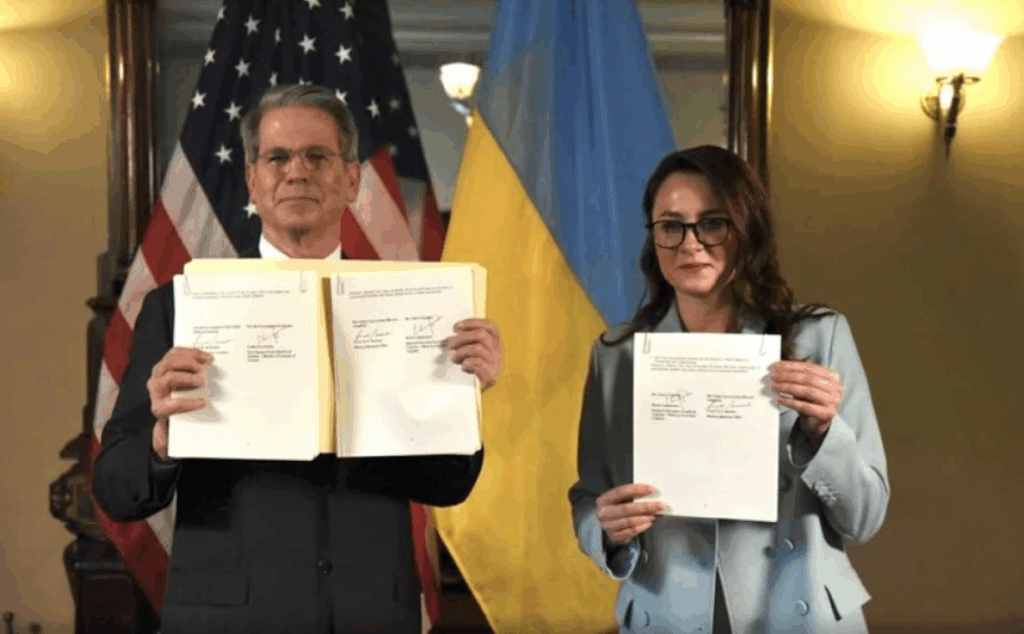 Особи тримають підписані угоди, прапори США та України.
