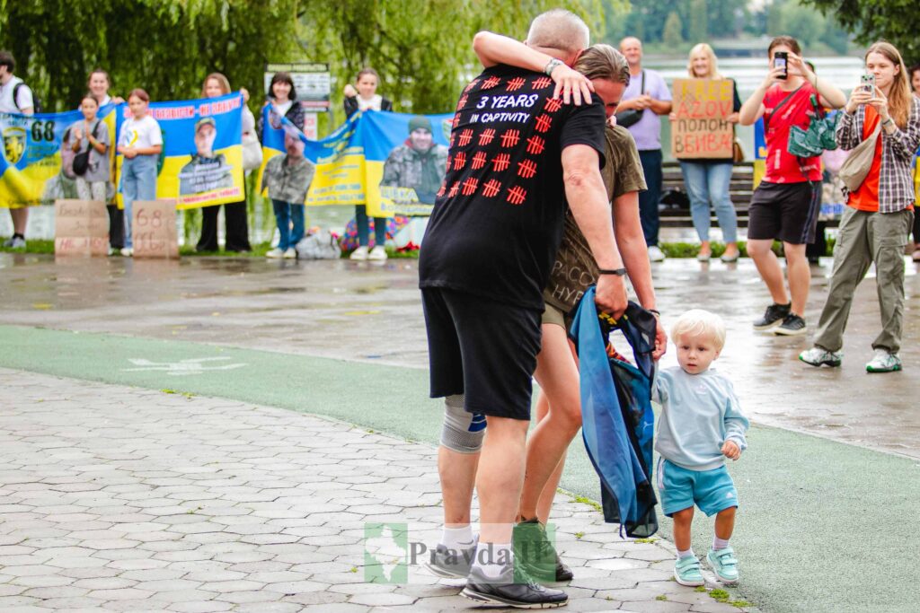 Люди з плакатами на вуличній демонстрації в Україні.