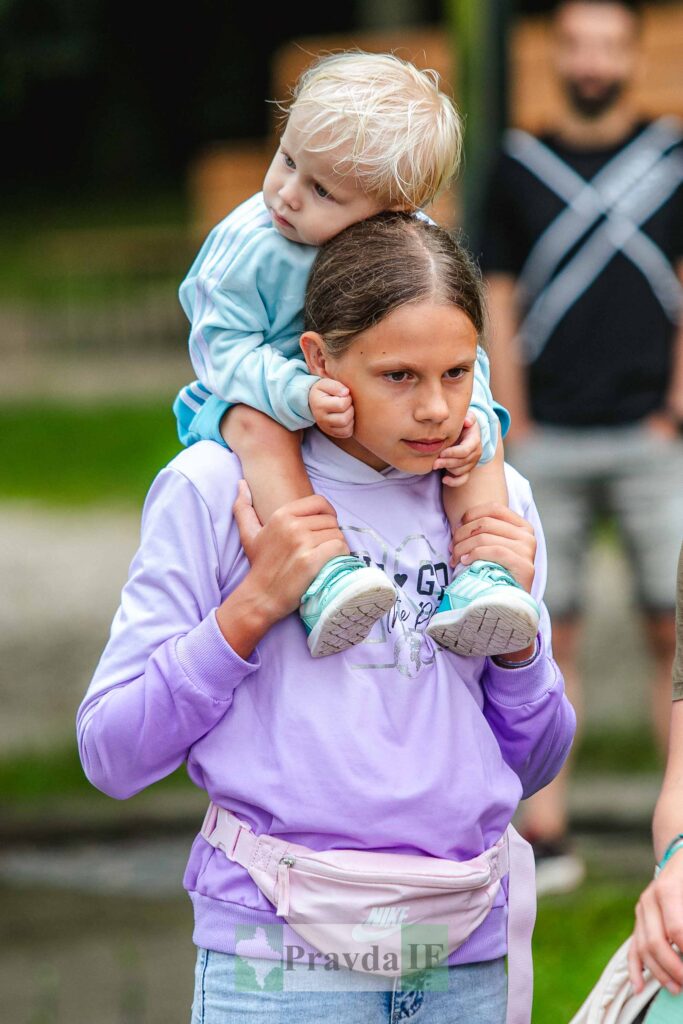 Діти граються на вулиці, мальчик на плечах.