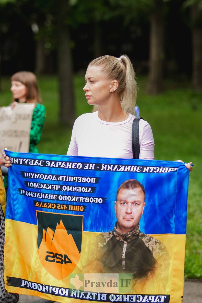 Жінка тримає плакат на вулиці
