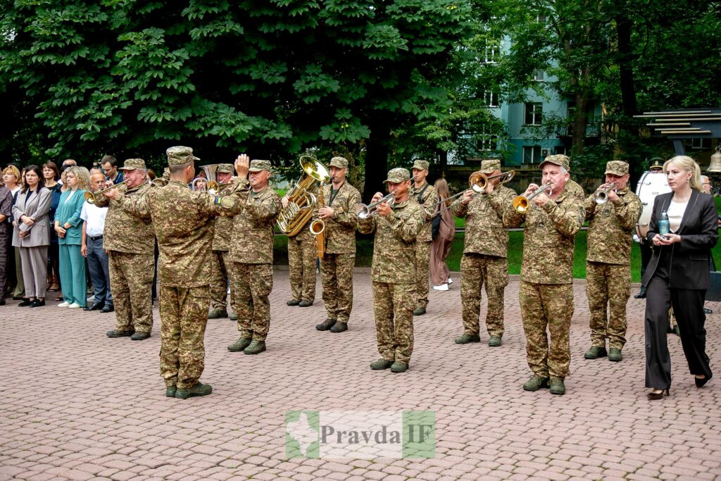 Військовий оркестр грає, люди слухають надворі.