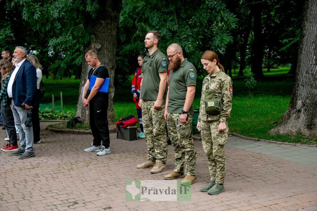 Військові та цивільні у парку на церемонії.
