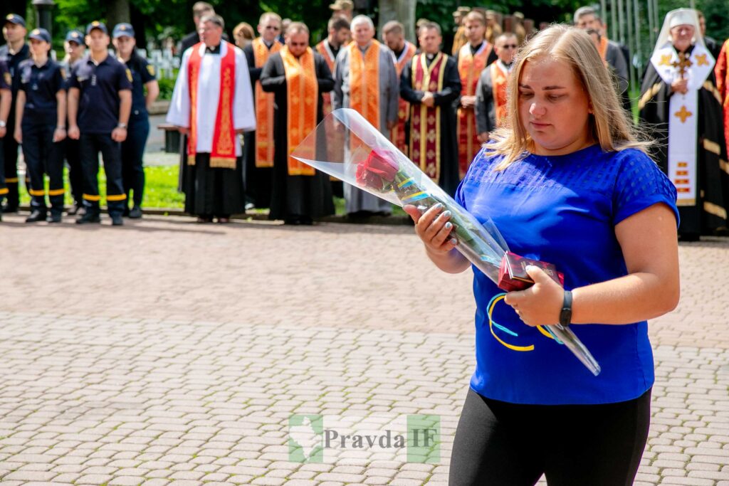 Жінка з трояндою на церемонії вшанування