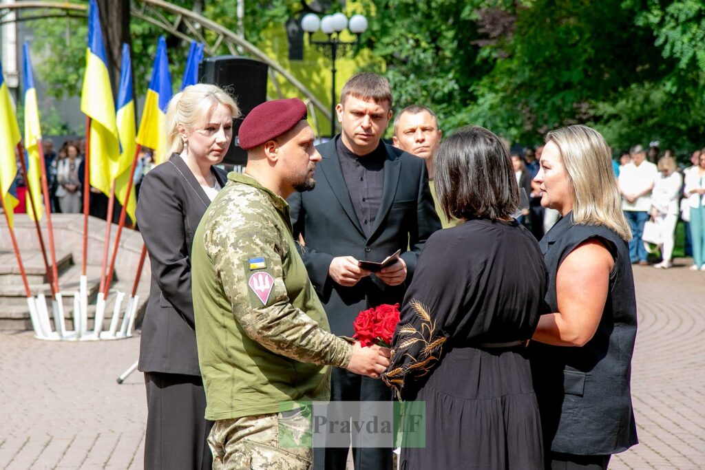 Церемонія з військовими в Україні, на фоні прапори.