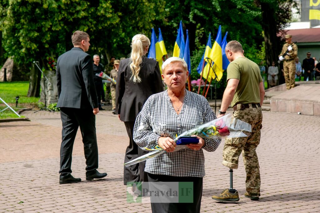 Церемонія вшанування, люди з квітами, прапори України