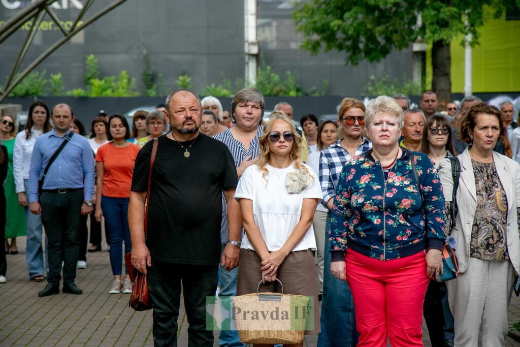 Група людей стоїть під відкритим небом на заході.