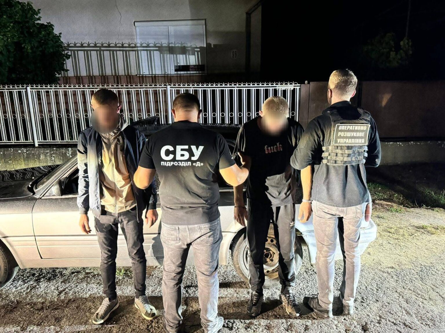 Затримання двох осіб поліцією біля автомобіля