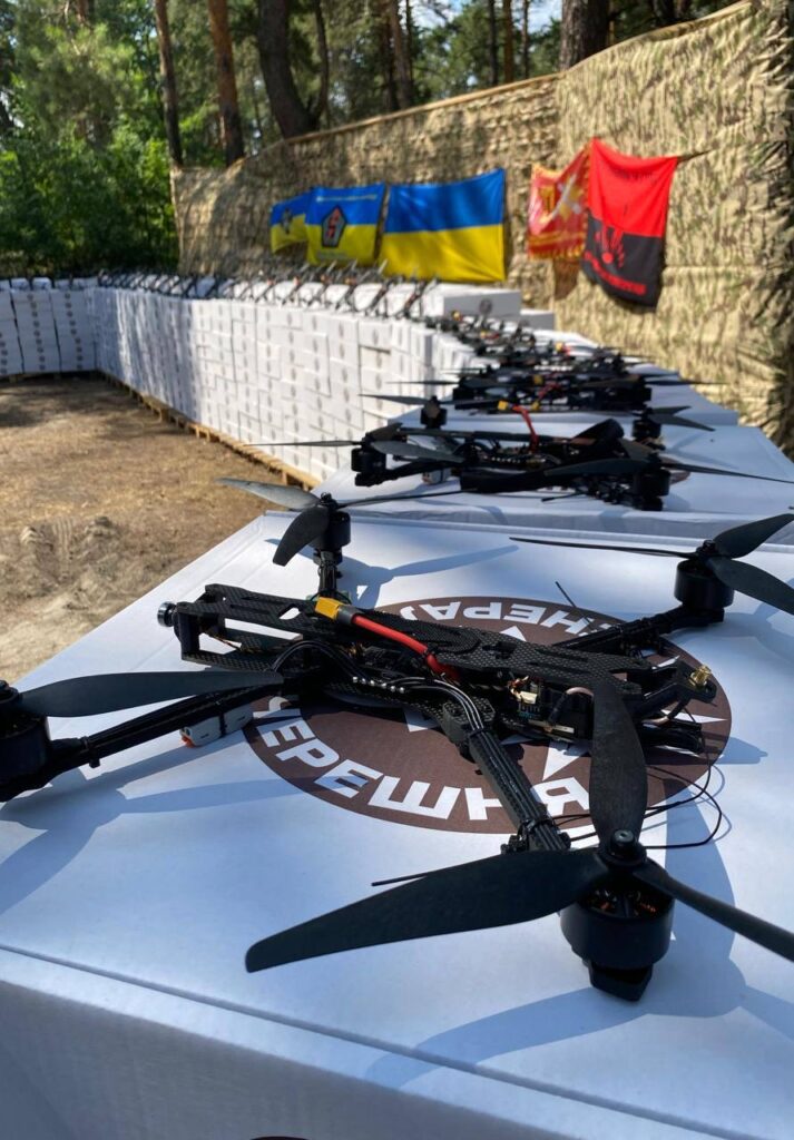 Безпілотники на столах з українськими прапорами