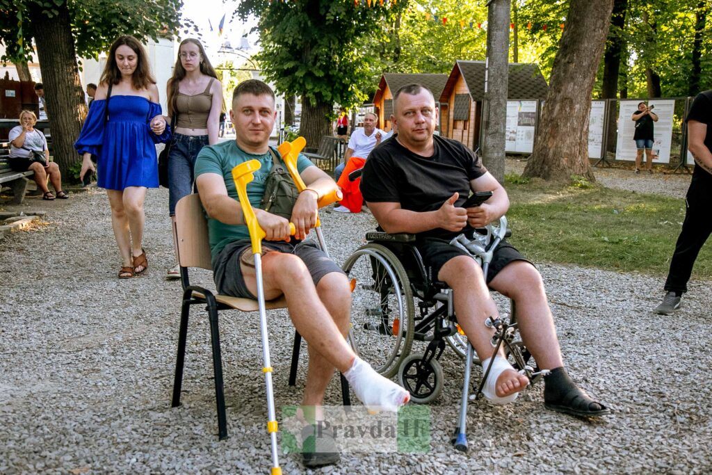 Люди в інвалідному візку і на милицях гуляють.