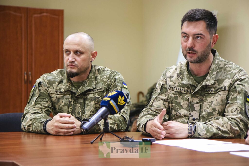 Військові на нараді, мікрофон на столі.