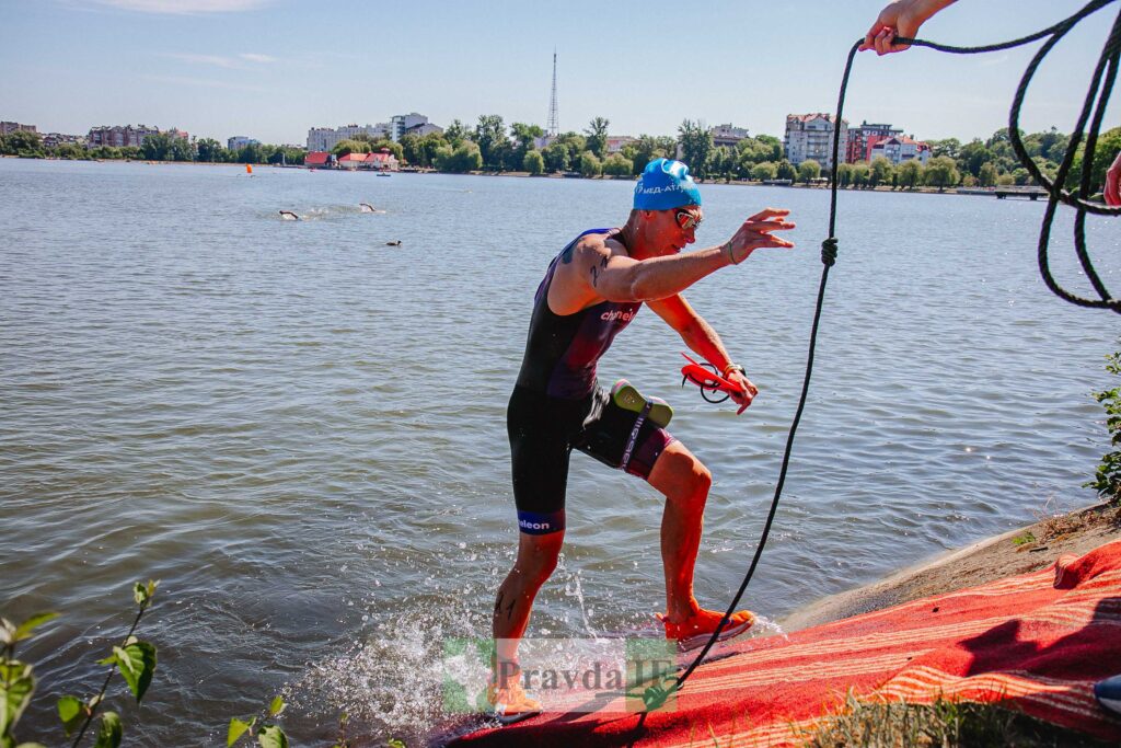 Тріатлон спортсмен виходить з води на берег.