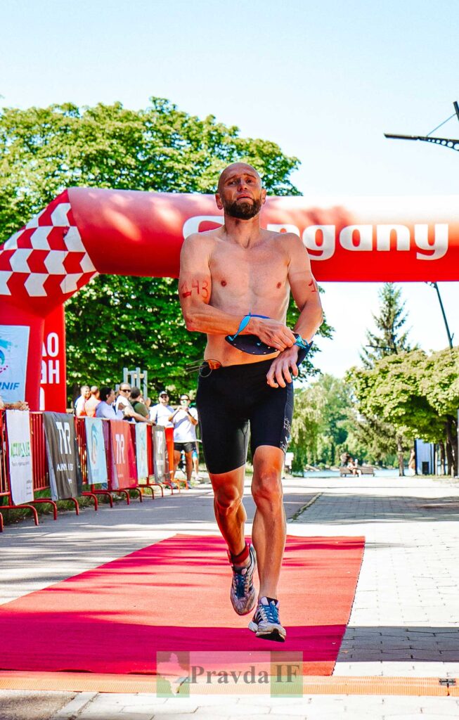 Спортсмен на марафоні, фінішує на червоній доріжці.