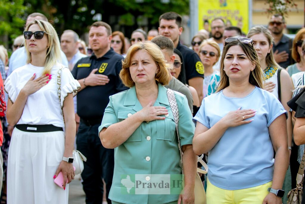 Група людей на урочистій події з прапором