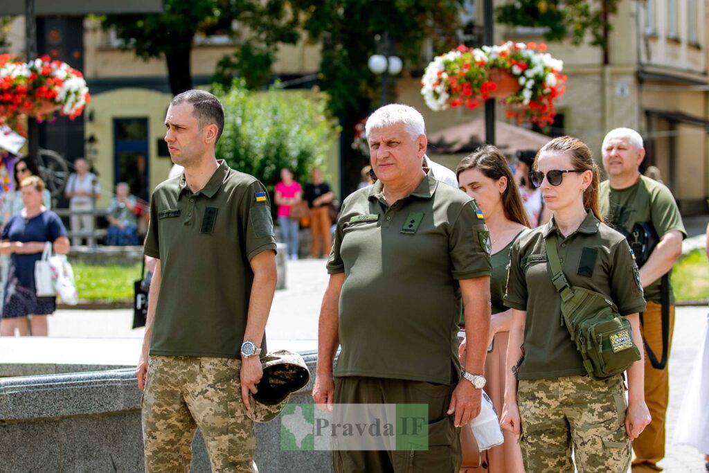 Люди у військовій формі під час заходу на вулиці.