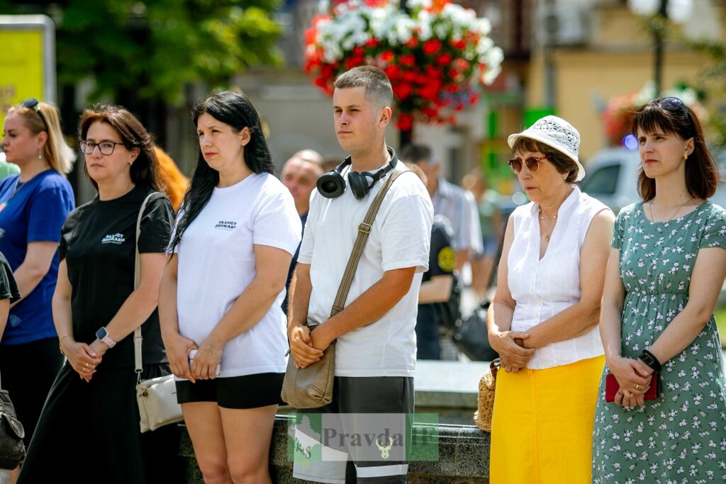 Люди на вулиці біля клумби з квітами.