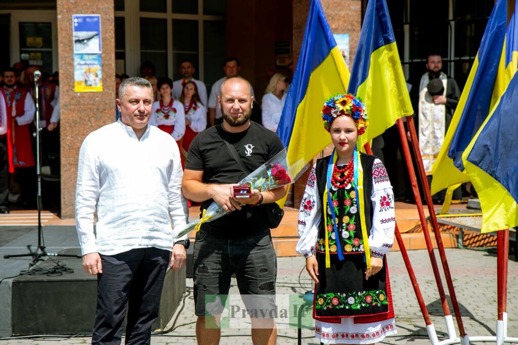 Люди біля прапорів святкують подію