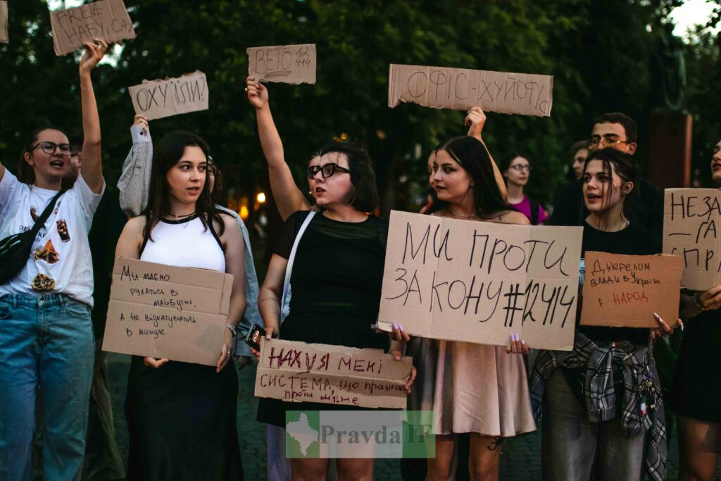 Протест проти закону в Україні, люди тримають плакати.