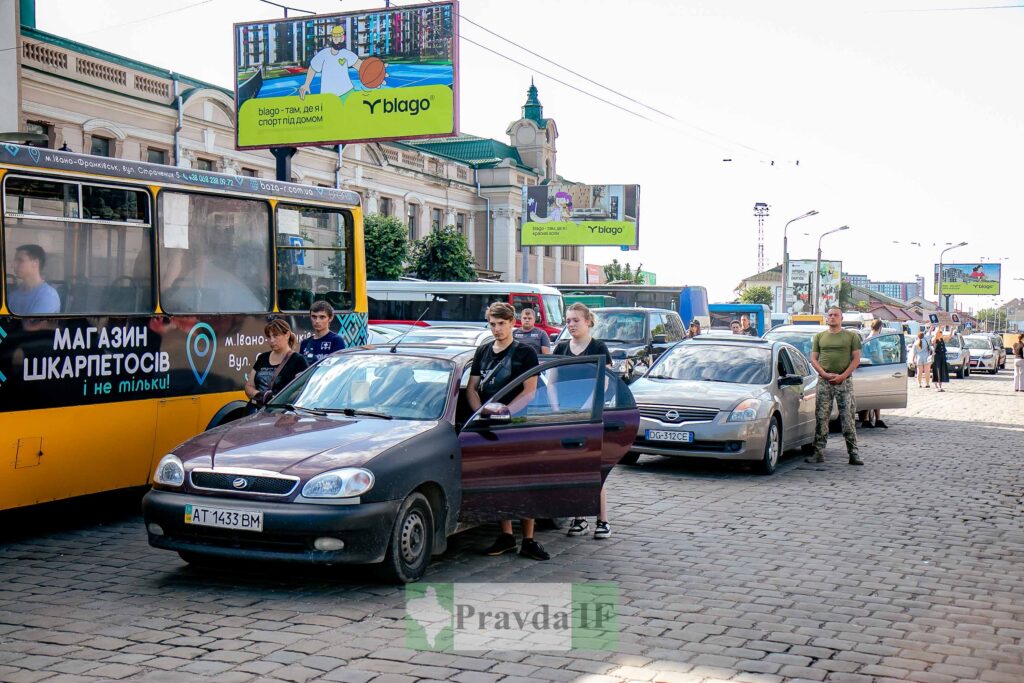 Люди виходять з автомобілів на жвавій вулиці.