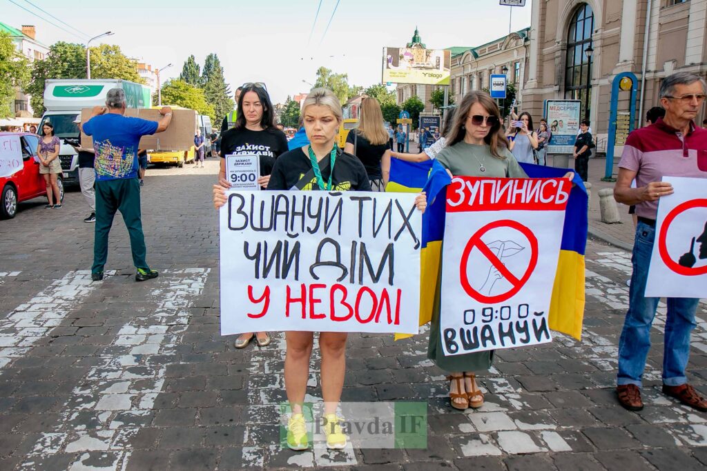 Протест із плакатами про патріотизм на вулиці.
