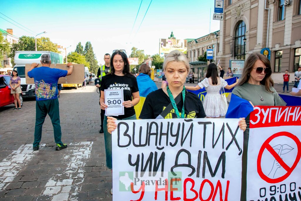 Люди на мирній акції з плакатами в Україні.