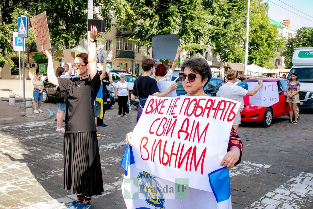 Люди на протесті з плакатами в Україні.