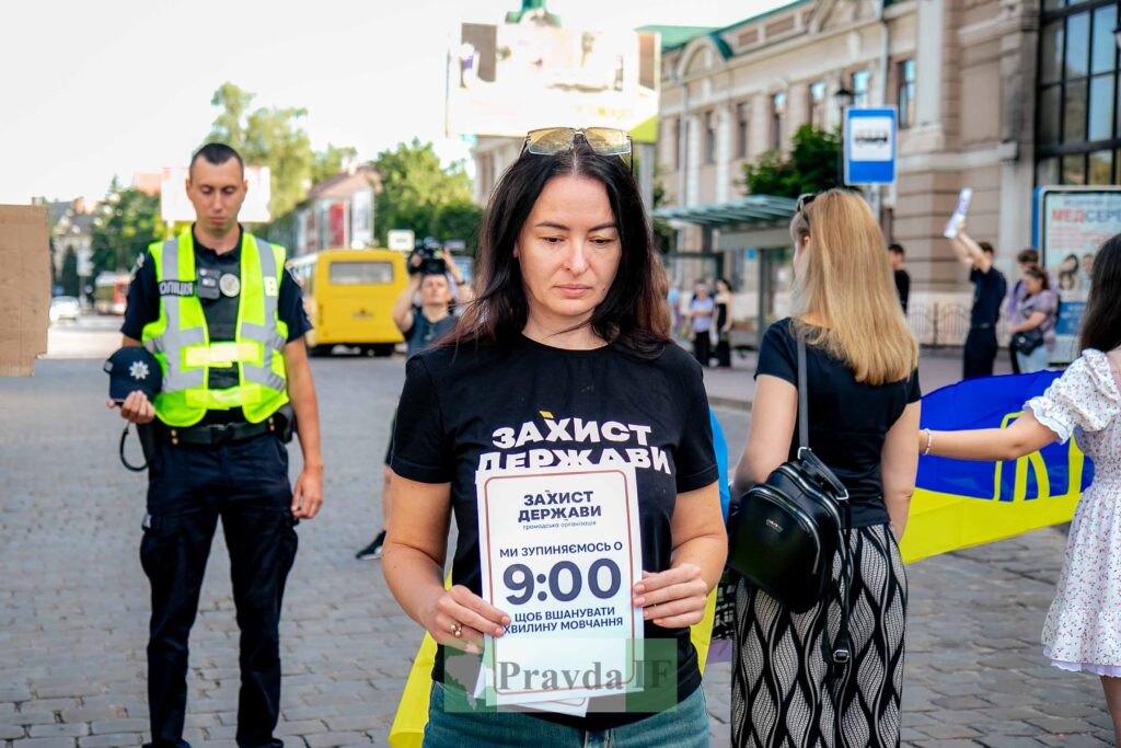 Жінка тримає плакат на акції протесту.