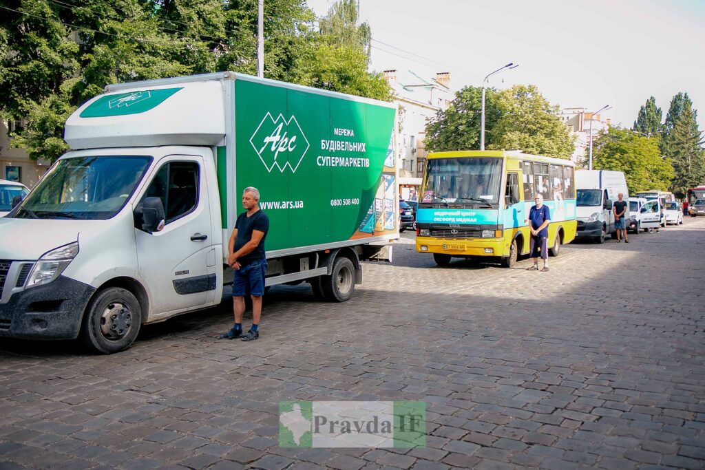 Вантажівка і автобус на дорозі в місті.