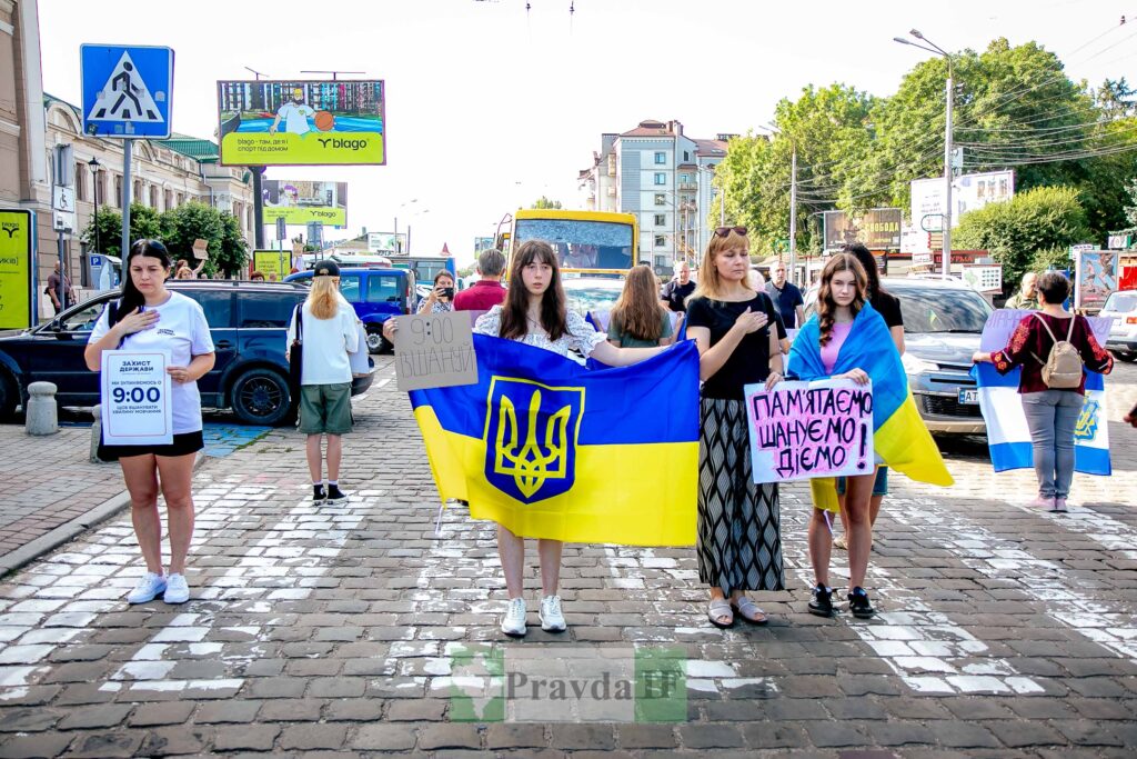 Протест з українськими прапорами на вулиці міста.