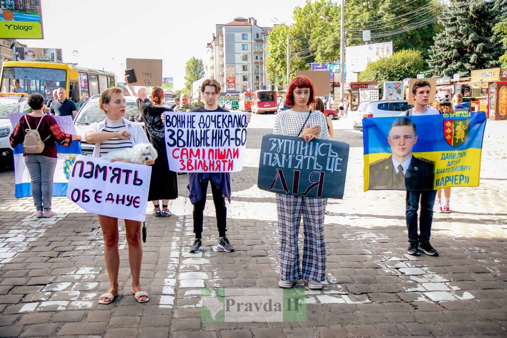 Люди тримають плакати на вулиці, протест акція.