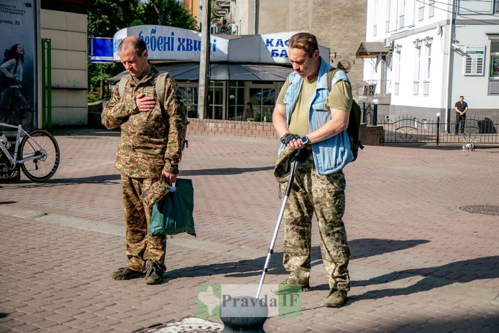 Двоє військових стоять на вулиці з білою тростиною.