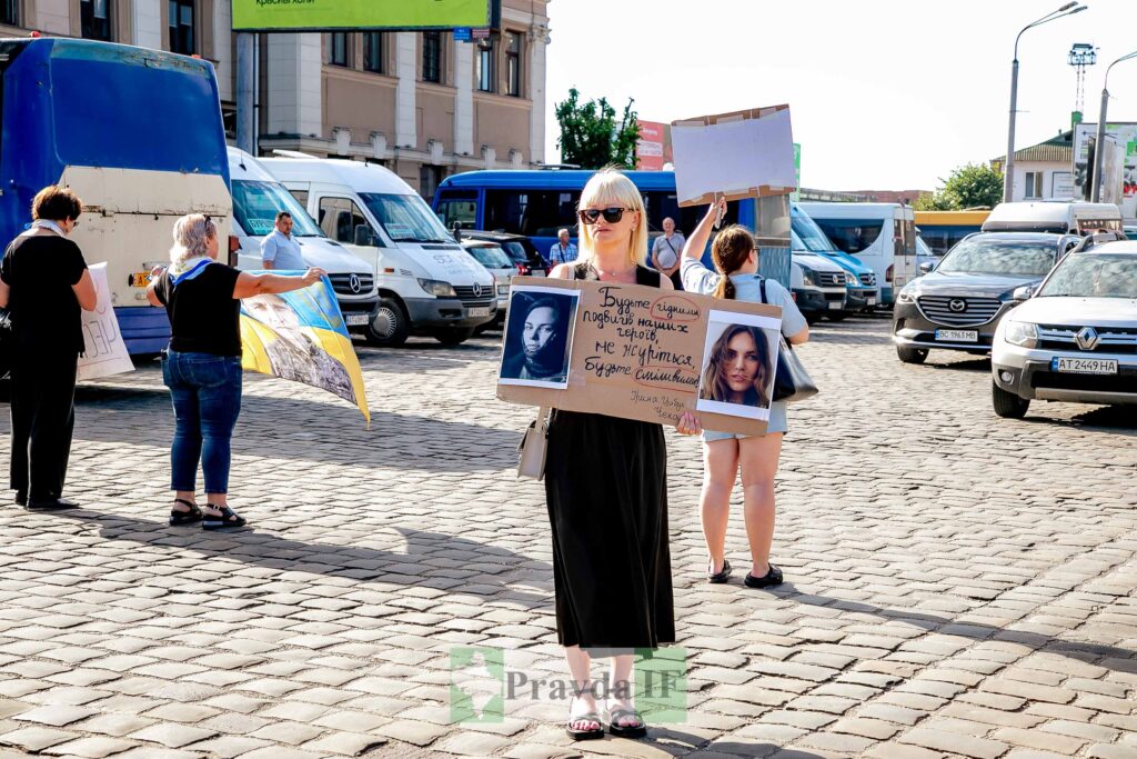 Люди з плакатами на мирній акції вулицею.