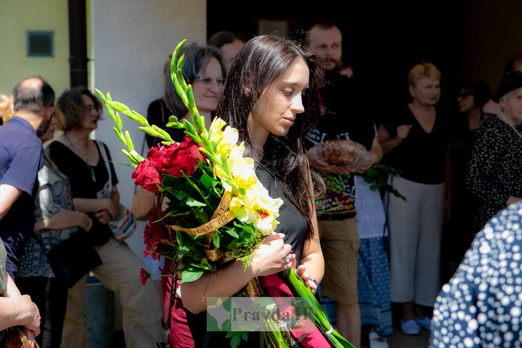 Жінка з квітами, серед людей на заході
