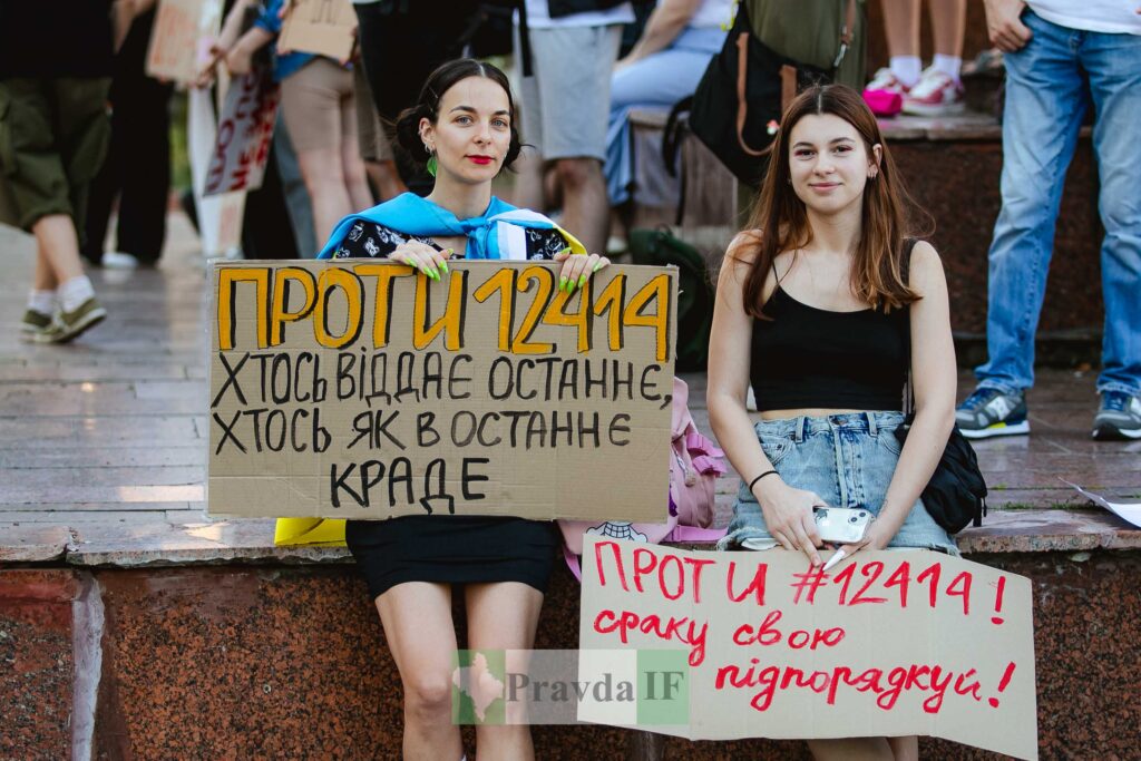 Люди тримають антиурядові плакати на протесті.