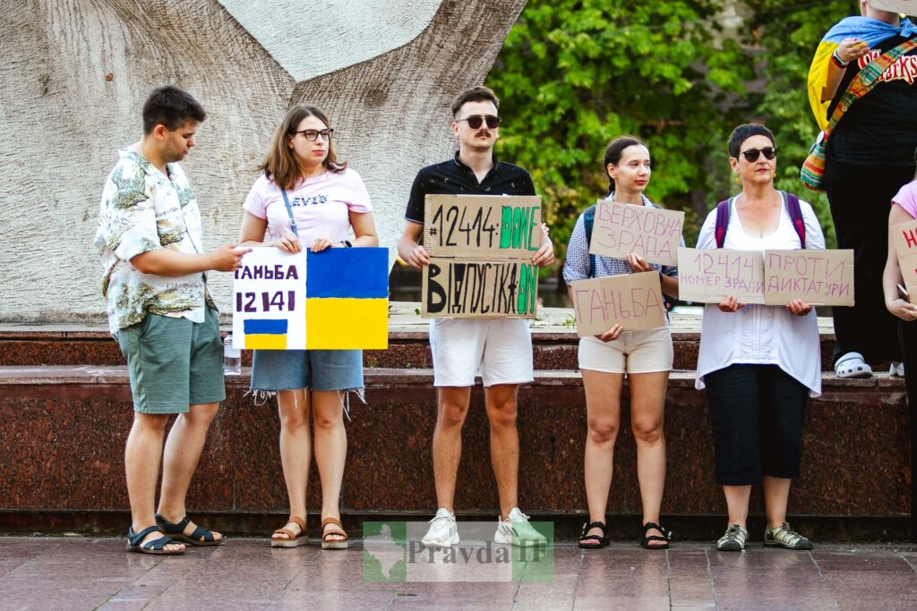 Люди з плакатами на вулиці, протестують.