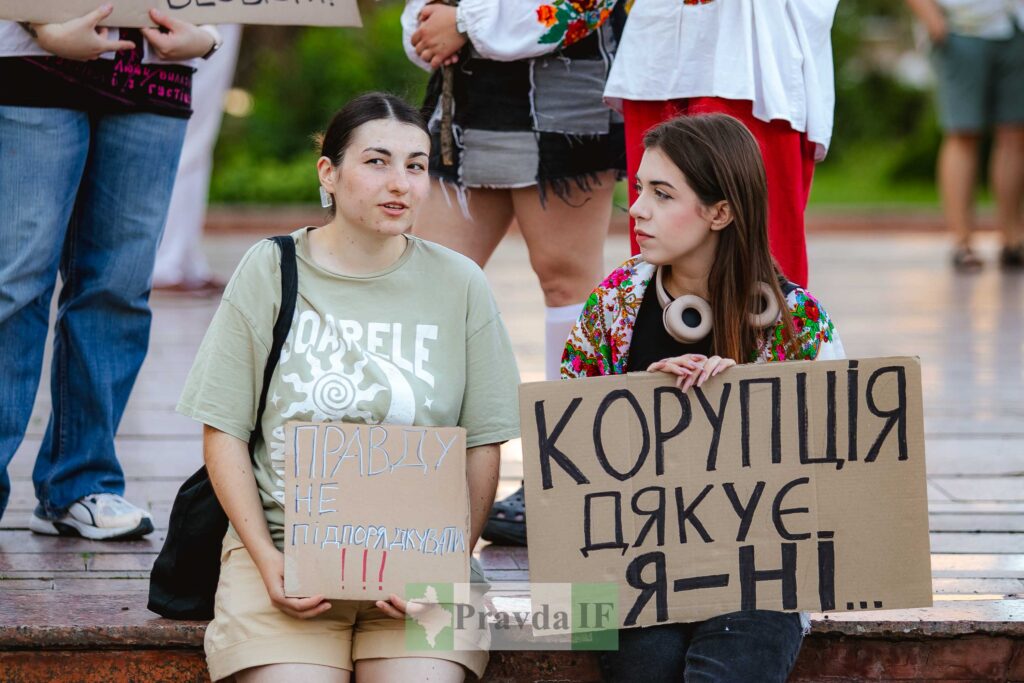 Люди тримають плакати з антикорупційними гаслами.