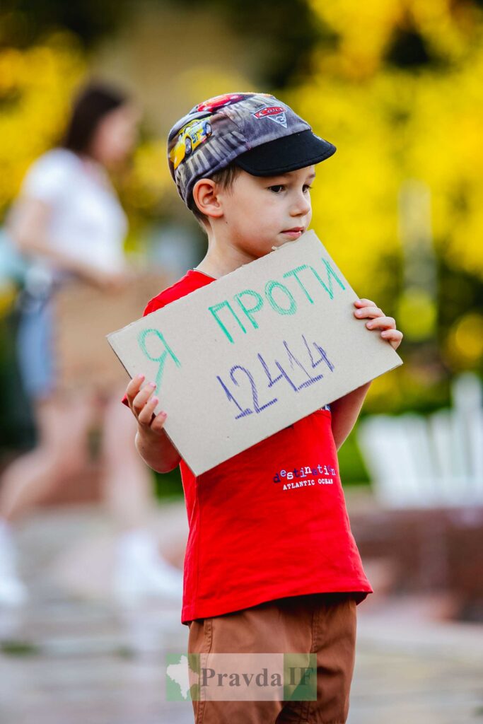 Дитина на протесті з картонним плакатом.