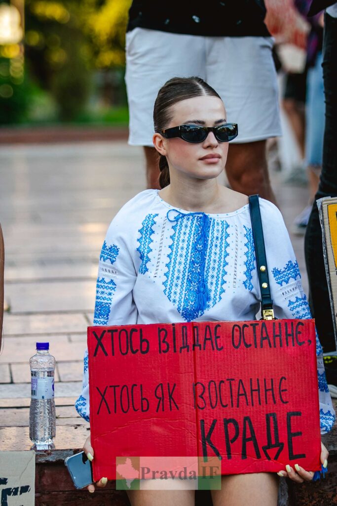 Дівчина з плакатом на мирному протесті.
