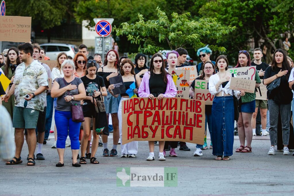 Люди на протесті з плакатами на вулиці.